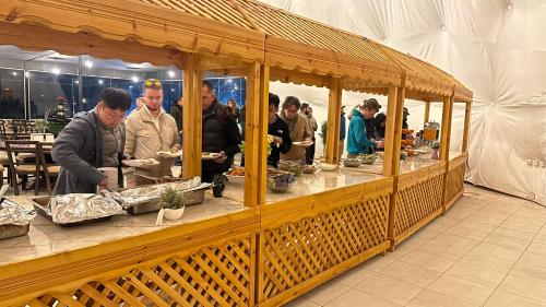 un gruppo di persone che si aggirano intorno a un buffet in una tenda di Rum Laura luxury camp a Wadi Rum