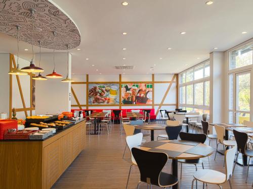 een restaurant met tafels en stoelen en een cafetaria bij ibis Igrejinha in Igrejinha