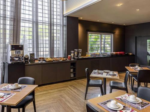 een restaurant met houten tafels en stoelen en een keuken bij Mercure Sao Bernardo Do Campo in São Bernardo do Campo