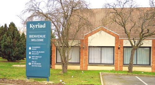 een bord voor een bakstenen gebouw bij Kyriad Argenteuil in Argenteuil