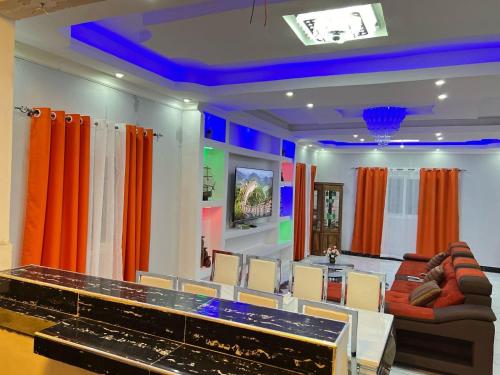 een kamer met oranje gordijnen en een tafel en stoelen bij Tranon'i Maria in Toamasina