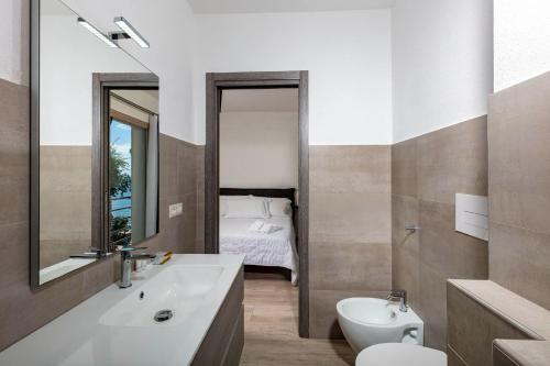 a bathroom with a sink and a toilet and a bed at Blue Bay rooms in Cala Gonone