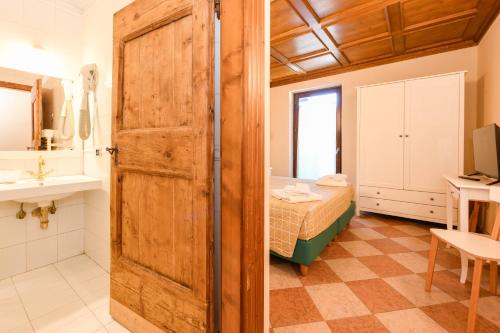 een badkamer met een deur naar een slaapkamer bij Albergo Locanda Mezzosoldo in Mortaso