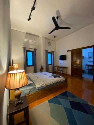 een slaapkamer met een bed en een tafel met een lamp bij Casa Primera in Luang Prabang