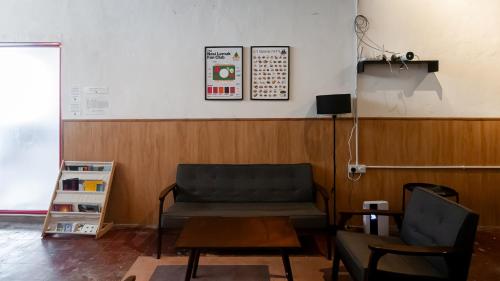 een wachtkamer met een bank en een tafel bij Aayu Seckchuan - 3 mins walk to Love Lane in George Town
