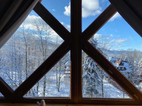 a window with a view of snow covered trees at Villa Kaplowa Chata & SPA in Zakopane
