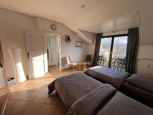 a bedroom with two beds and a large window at Ferienwohnung mit Garten am Venekotensee in Niederkrüchten