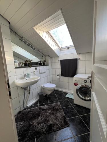 a bathroom with a sink and a washing machine at Ferienwohnung mit Garten am Venekotensee in Niederkrüchten