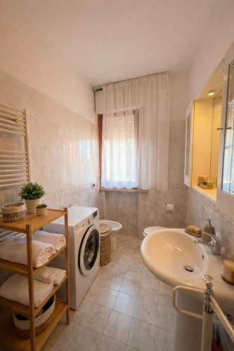 a bathroom with a washing machine and a sink at Cleos Home con Giardino Privato e Free Parking in Arezzo