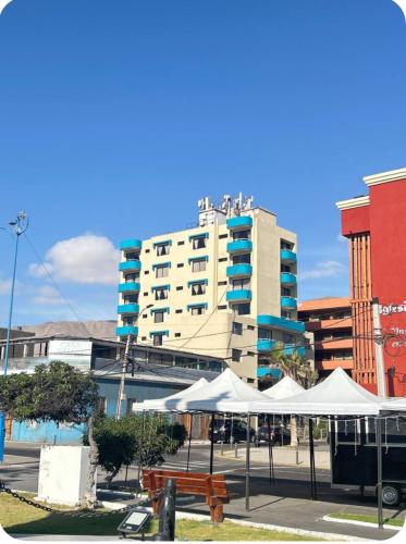 un grande edificio con ombrelli bianchi in una città di Hotel Capri a Iquique