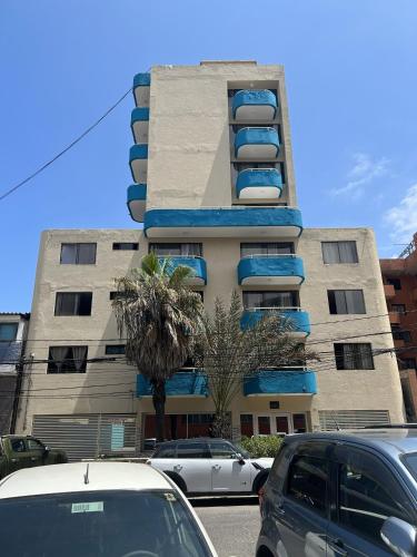 a tall building with cars parked in front of it at Hotel Capri in Iquique