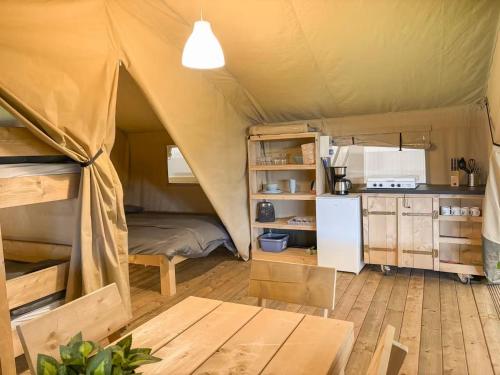 a room with a tent with a refrigerator and a table at Himmerland camping & Feriecenter in Års