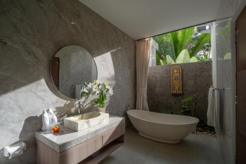 a bathroom with a tub and a sink and a mirror at Waringin Villa Ubud in Ubud