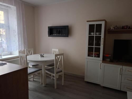 una sala da pranzo con un tavolo e una TV a parete di Apartament BLISKO SZLAKU a Boguszów-Gorce