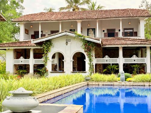 een huis met een zwembad ervoor bij Villa Kubura in Hikkaduwa