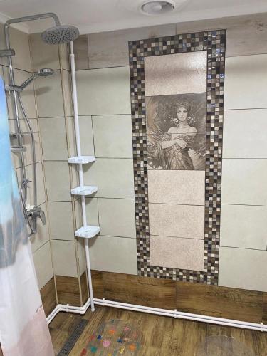 a bathroom with a painting of a woman on the wall at Căsuța Bunicilor de la Munte in Ceahlău