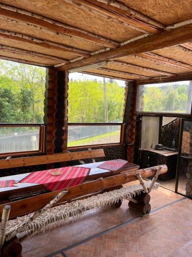 a room with a bed and a bench in it at Căsuța Bunicilor de la Munte in Ceahlău