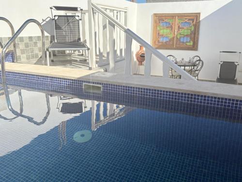 een huis met een zwembad met een stoel en een trap bij Perle de sable in Dakhla