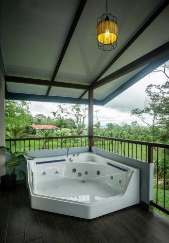a jacuzzi tub on a balcony with a view at Divan Jungle Lodge in Fortuna