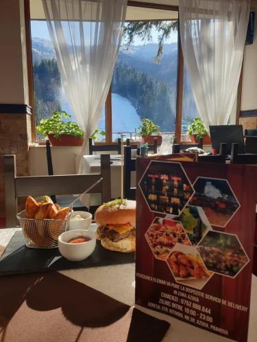 une table avec une boîte de pizza et du pain dans l'établissement Pensiunea ELEMAR, à Azuga