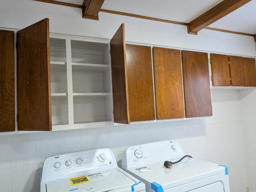 een keuken met een witte kachel en houten kasten bij Ici Chez Vous in Trois-Rivières