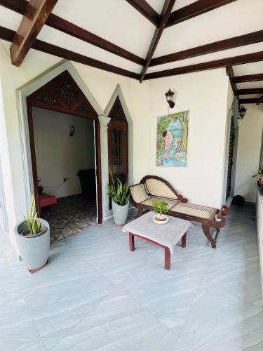 a patio with a bench and a table at Villa Kethmin in Talpe