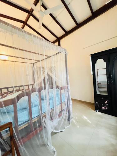 a bed in a room with a mosquito net at Villa Kethmin in Talpe