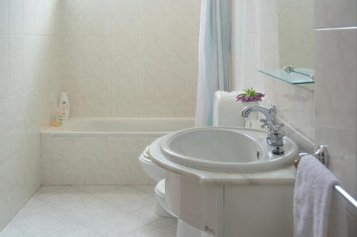 a bathroom with a sink and a toilet and a tub at Cantinho da Celeste in Paramos