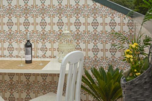 una sedia bianca accanto a un tavolo con una bottiglia di vino di Cantinho da Celeste a Paramos