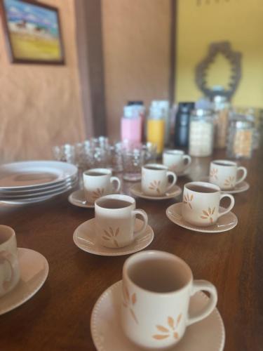 ein Holztisch mit weißen Tassen und Untertassen in der Unterkunft Hotel Fazenda Alta Vista in Fortim