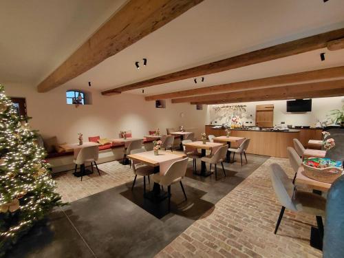 a restaurant with tables and chairs and a christmas tree at Hoeve De Hemel in Zuienkerke