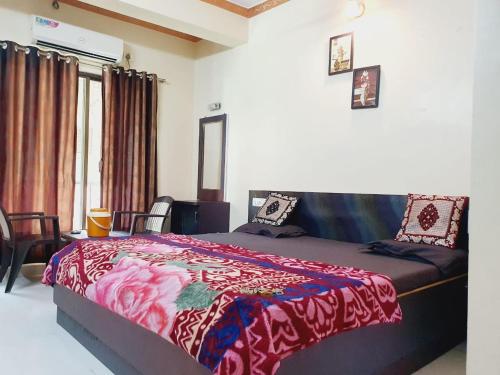 a bedroom with a bed with a red blanket at Hiral residency in Matheran