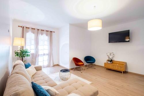 a living room with a couch and a tv at Casa do Neves in Funchal