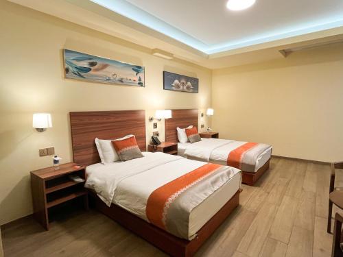 a hotel room with two beds and two lamps at SM HOTEL Plus in Lima