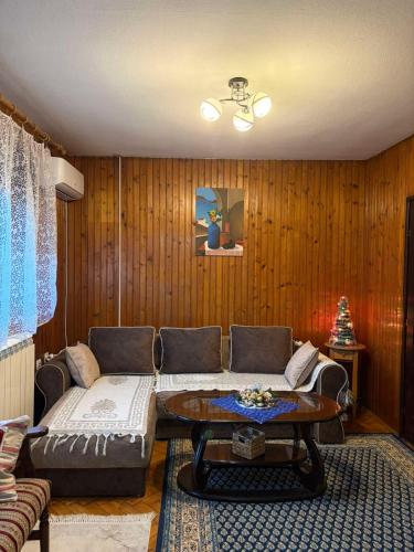 een woonkamer met een bank en een tafel bij Apartman 23 in Kraljevo
