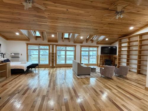 een slaapkamer met houten plafonds, een bed en een tv bij Lake Rd E- Geneva in Saybrook-on-the-lake