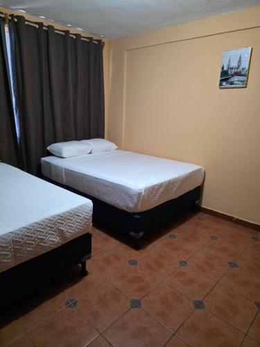 een slaapkamer met twee bedden en een raam bij Hotel y Restaurante Punta Corona in Acajutla