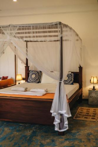 a bedroom with a large bed with a canopy at My Home Villa in Hikkaduwa