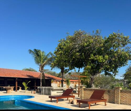 een zwembad met twee stoelen naast een huis bij Hotel Fazenda Alta Vista in Fortim