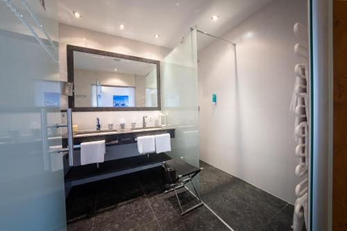 a bathroom with a sink and a mirror at Hotel Trisanna in Ischgl