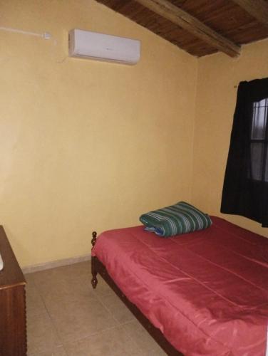 a bedroom with a bed with a red sheets and a window at CABAÑA NUESTRO HOGAR in San Rafael