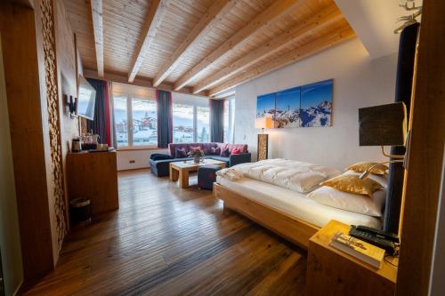 a bedroom with a bed and a living room at Hotel Trisanna in Ischgl