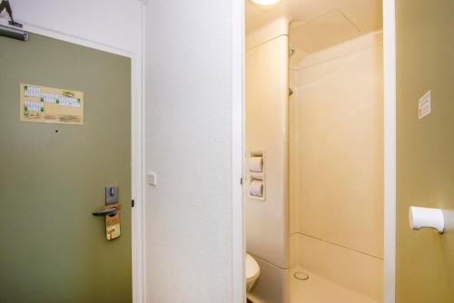 a bathroom with a toilet and a toilet paper dispenser at ibis Budget Canberra in Canberra