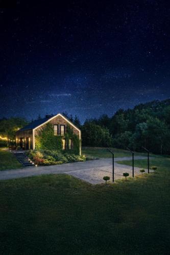 a house with lights on the side of it at night at Rezydencja Bieszczady - Solina in Solina