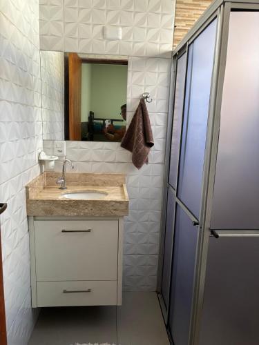 a bathroom with a sink and a mirror and a refrigerator at Casa Toledo in Olímpia