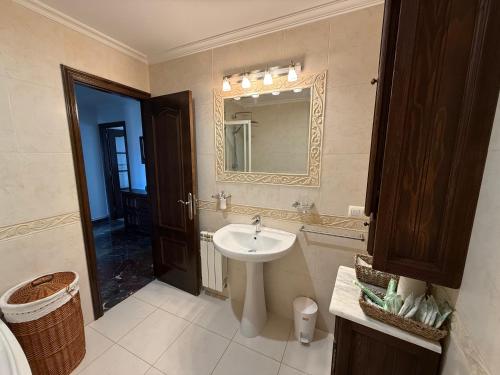 een badkamer met een wastafel en een spiegel bij A CALZADA in Cambados