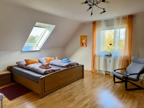 a room with a bed and a window and a chair at Eifeleule in Hürtgenwald
