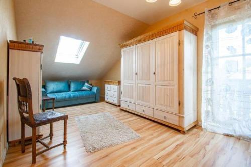 a living room with a blue couch and a window at Landhaus Nadine in Kolonie Roeske