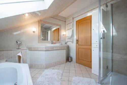 a bathroom with a tub and a sink and a shower at Landhaus Nadine in Kolonie Roeske