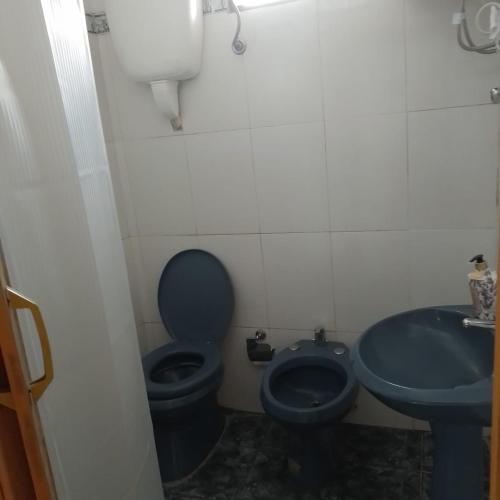 a bathroom with a blue toilet and a sink at La Olimareña in Treinta y Tres